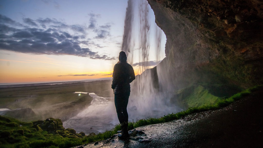 Bild zeigt einen Mensch unter einem Wasserfall