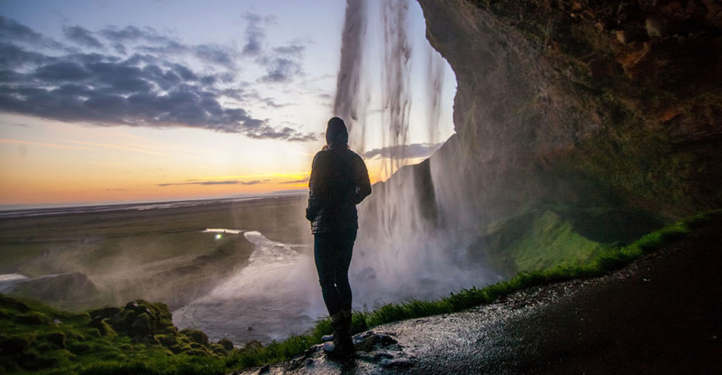 BIld zeigt eine Frau vor einem Wasserfall